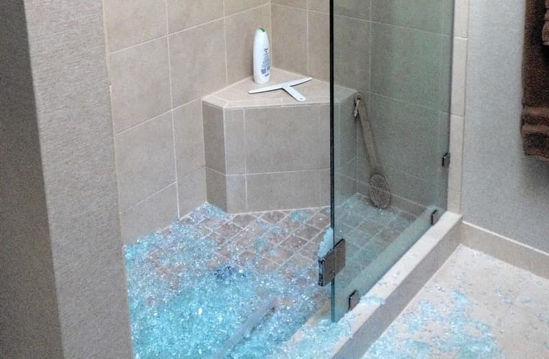 Розбите гартоване скло в душовій кабіні